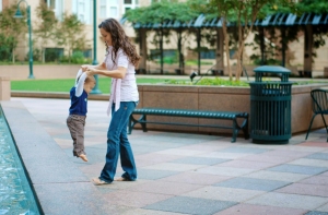 Woman and child by waterscape in city park